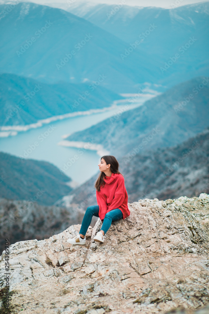 Beautiful Young Girl in a cosy red sweater on Mountain top Beautiful Young Girl in a cosy red sweater on Mountain top