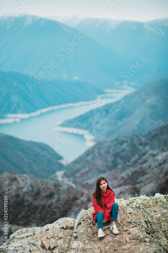 Beautiful Young Girl in a cosy red sweater on Mountain top