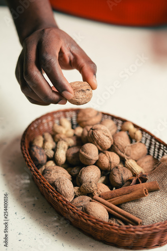 Close up offhand taking walnut from the basket on the table photo