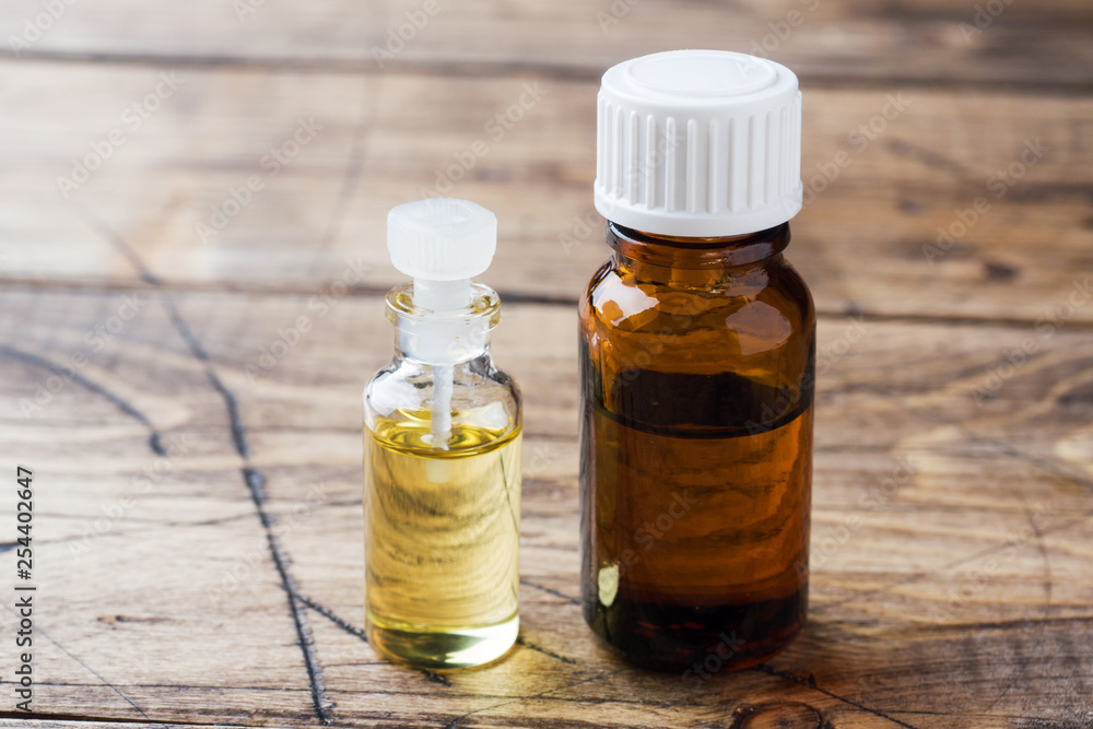 Jars of essential oils on a wooden background with copy space. Jars of essential oils on a wooden background with copy space.