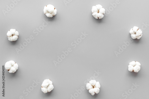 Cotton flowers frame on grey background top view copy space