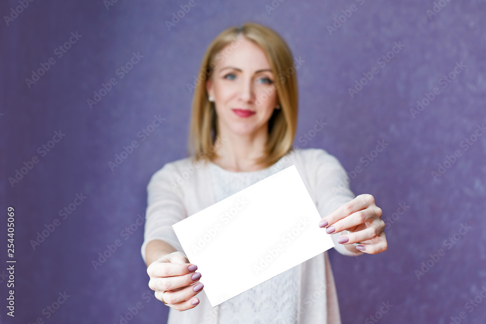 Naklejka premium A woman in bright clothes holding a white sheet on a purple background