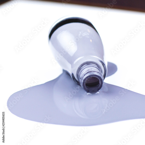 A jar of spilled varnish gray-purple color on a white background.