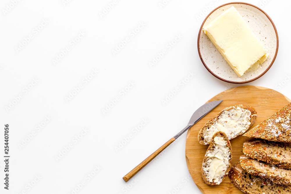 Slice of bread with butter on white background top view copy space Slice of bread with butter on white background top view copy space