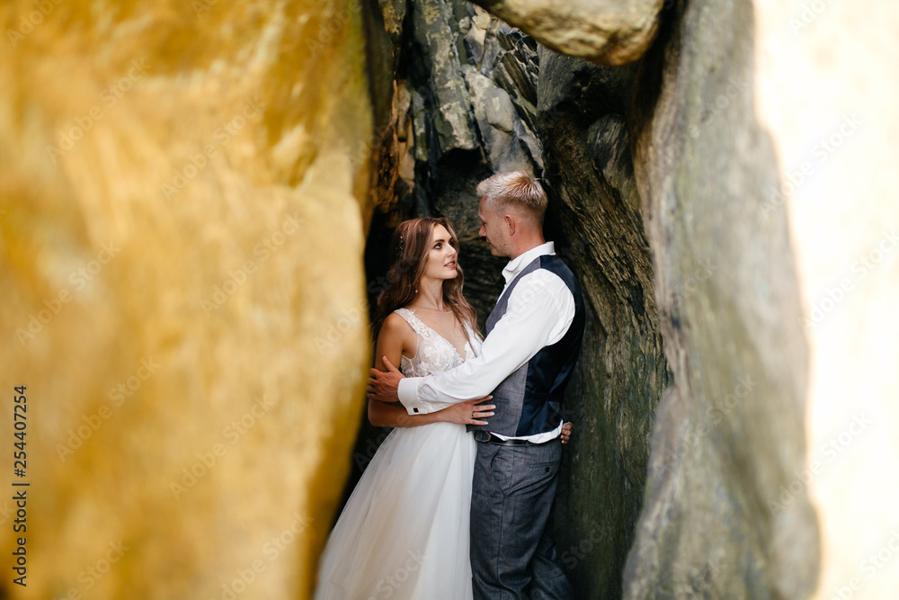 Beautiful wedding couple, bride and groom, in love on the background of mountains Beautiful wedding couple, bride and groom, in love on the background of mountains