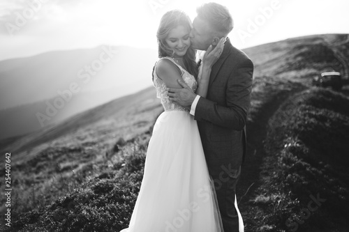 Foto Beautiful wedding couple, bride and groom, in love on the background of mountain