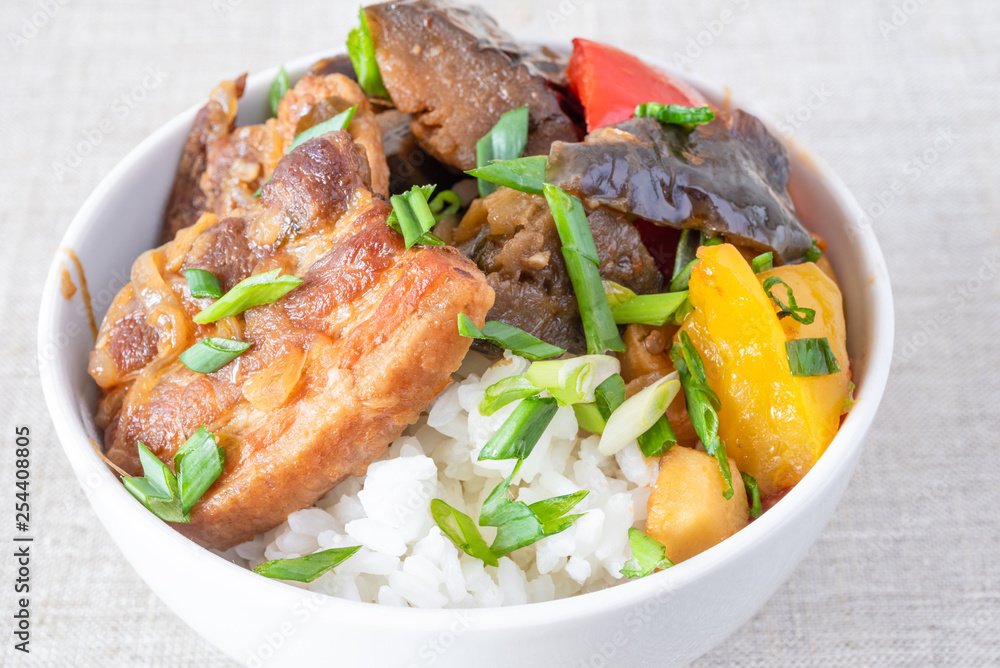 Bowl of rice with spicy pork and vegetables close up - traditional asian dish Bowl of rice with spicy pork and vegetables close up - traditional asian dish
