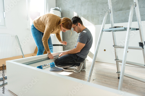 Couple assembling furniture in their new house 