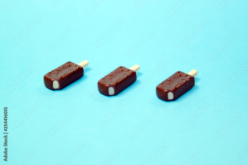 Fototapeta premium classic bitten popsicles choc-ice Lollipop ice cream in chocolate glaze on blue pastel background