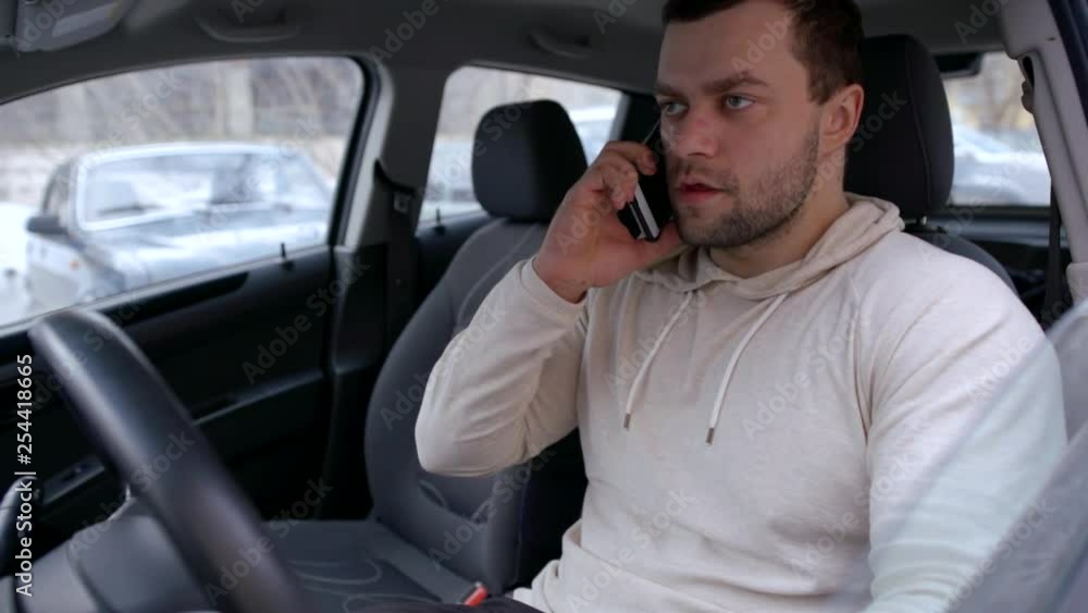 Man becomes angry talking on the phone in a car. Man becomes angry talking on the phone in a car.