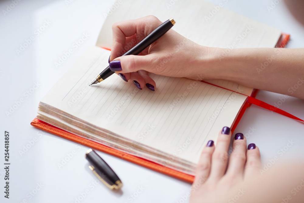 woman's hand writing notes in diary woman's hand writing notes in diary