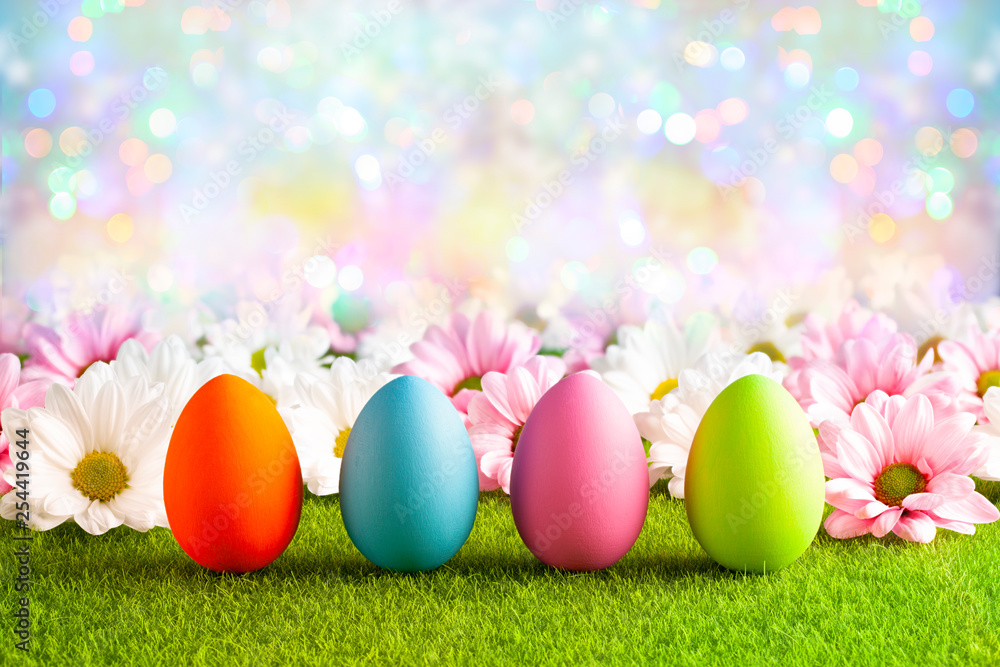Pink and white flowers and Easter eggs on the grass and colorful abstract background Pink and white flowers and Easter eggs on the grass and colorful abstract background