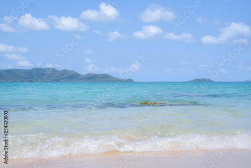 Beautiful beach with soft wave of tropical sea and blue sky. Summer day concept. Vacation and holidays concept.