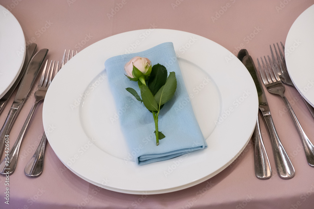 Table with a pink tablecloth, served and decorated with roses Table with a pink tablecloth, served and decorated with roses