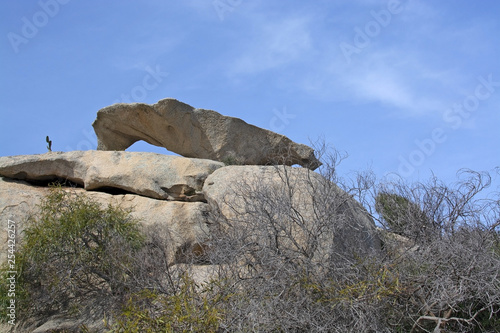 Slab of granite rock lying on top of eroded cliff