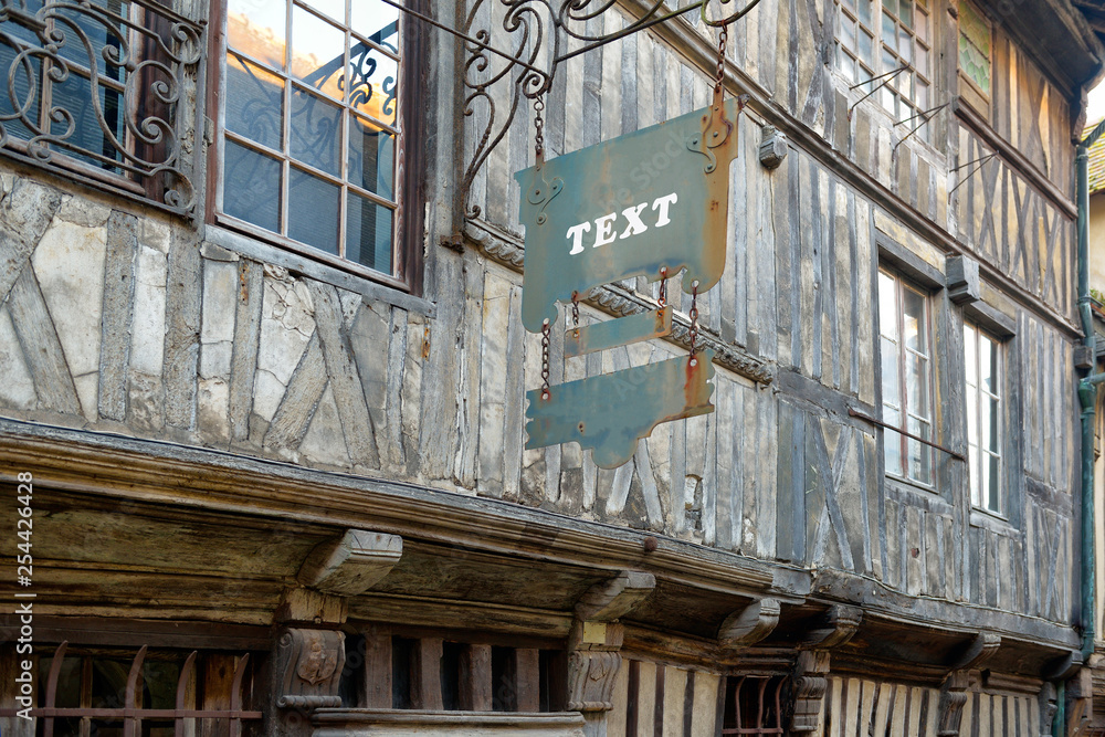 Hanging sign advertising panel on facade of an old European wooden building. Hanging sign advertising panel on facade of an old European wooden building.