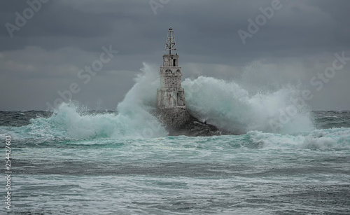 Lighthouse in the port of Ahtopol, Black Sea, Bulgaria.Large waves break into the old lighthouse.