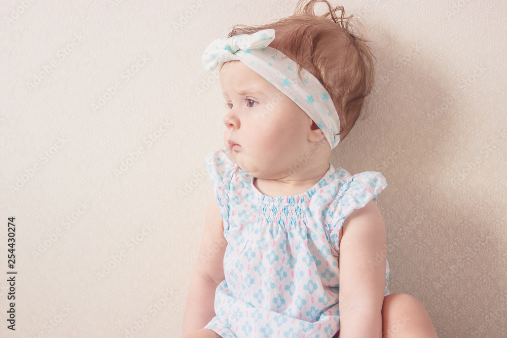 Portrait of eight month girl in the dress with headband, indoors Portrait of eight month girl in the dress with headband, indoors