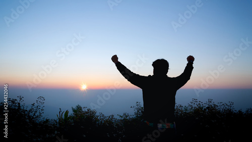 thankful man open arms to the sunrise stand top of mountain