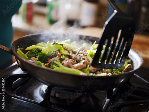 Fotografie cooking beef and broccoli stir-fry in hot pain inside home kitchen