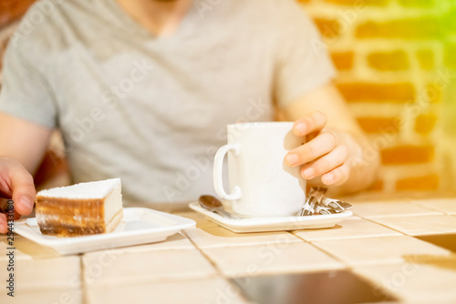 young attractive man having lunch with dessert and coffe in a restaurant