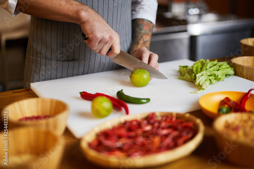 Closeup portrait of unrecognizable chef cutting vegetables while cooking spicy dish in restaurant  copy space
