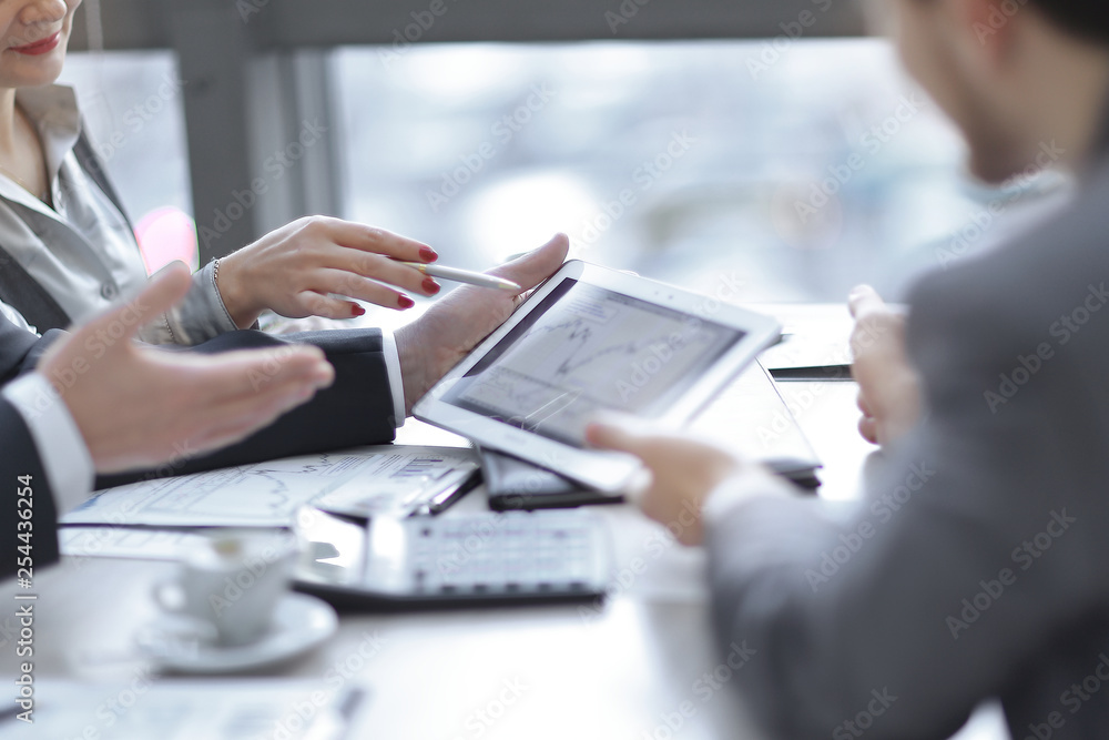 business team uses a digital tablet to check financial data. business team uses a digital tablet to check financial data.