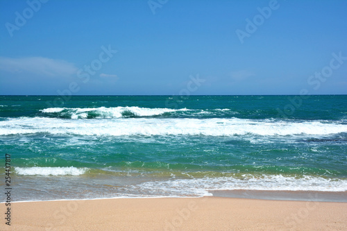 Beautiful tropical beach. Waves with crests breaking on the coast. Sri Lanka