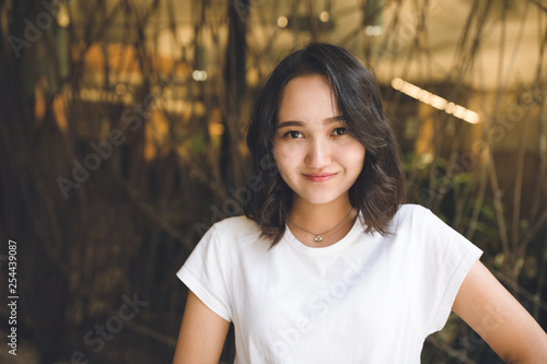 Cheerful optimistic asian girl in a white t-shirt, smiling