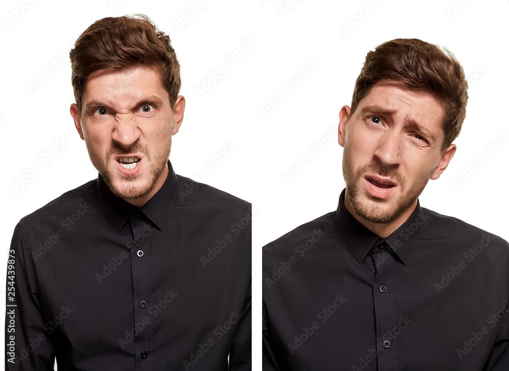 Handsome man in a black shirt makes faces, standing against a white background Handsome man in a black shirt makes faces, standing against a white background