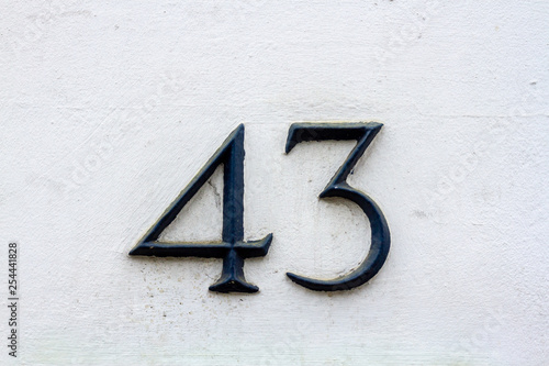 Number 43 in elegant black lettering on a white outside wall