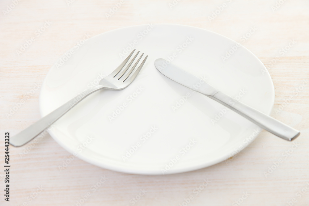white dish on the white wooden table with cutlery meaning PAUSE white dish on the white wooden table with cutlery meaning PAUSE