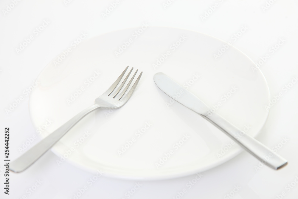 white dish on the white table with cutlery meaning PAUSE white dish on the white table with cutlery meaning PAUSE