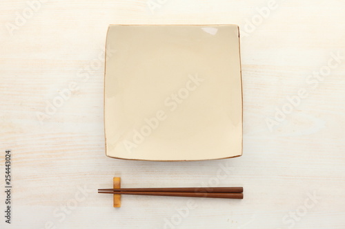 empty clay dish with chopsticks on the whtie wooden table