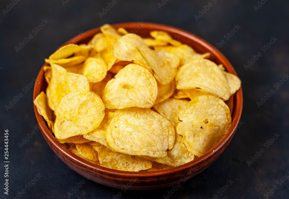 Crispy chips in a bowl on a stone background Crispy chips in a bowl on a stone background