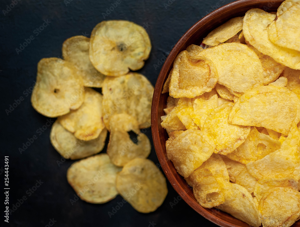Crispy chips in a bowl on a stone background