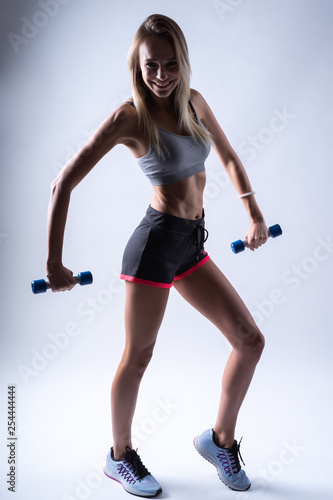 young woman with dumbbell on white background