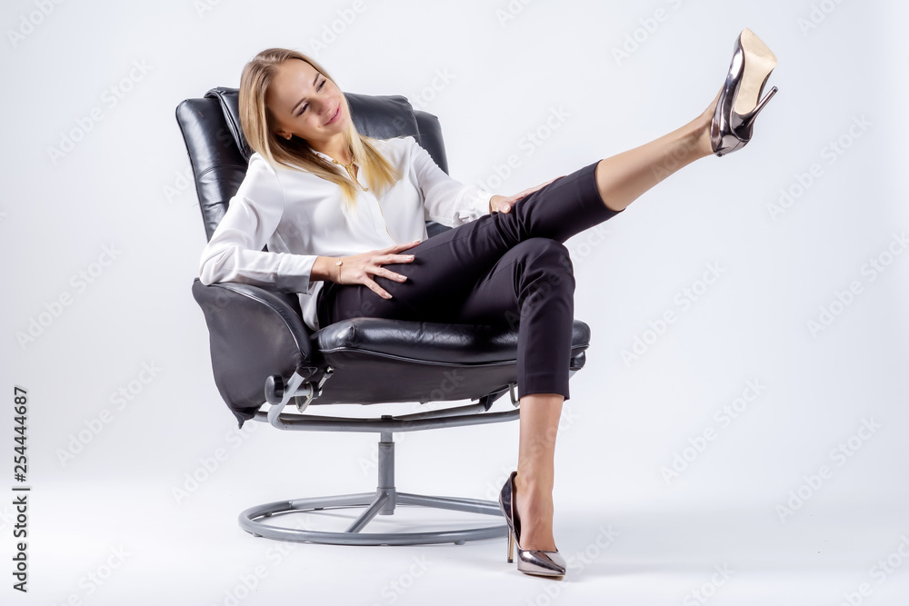 Young woman sitting on a chair with pulled leg Young woman sitting on a chair with pulled leg
