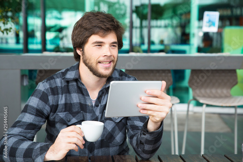 Happy positive guy enjoying movie on gadget screen