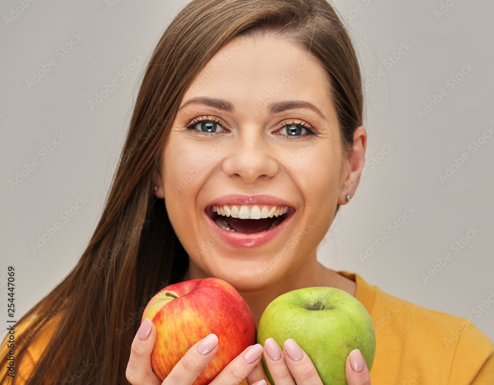 woman smiling with healthy teeth holding two apples. woman smiling with healthy teeth holding two apples.