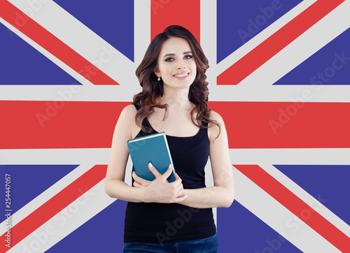 Smiling girl on the UK flag background. Pretty cheerful woman learning english language and traveling in United Kingdom