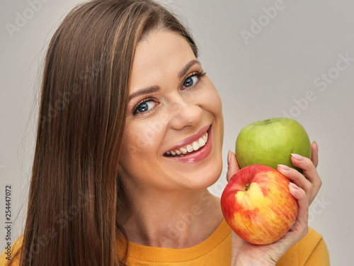 woman smiling with healthy teeth holding two apples. photo