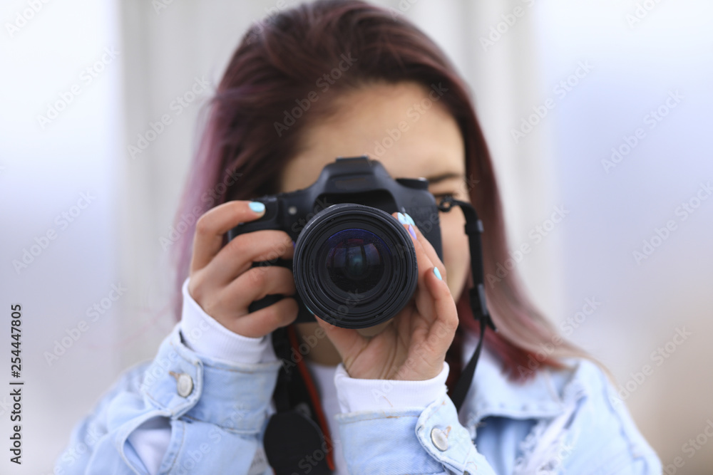 girl with a camera in a denim jacket looks into the lens girl with a camera in a denim jacket looks into the lens