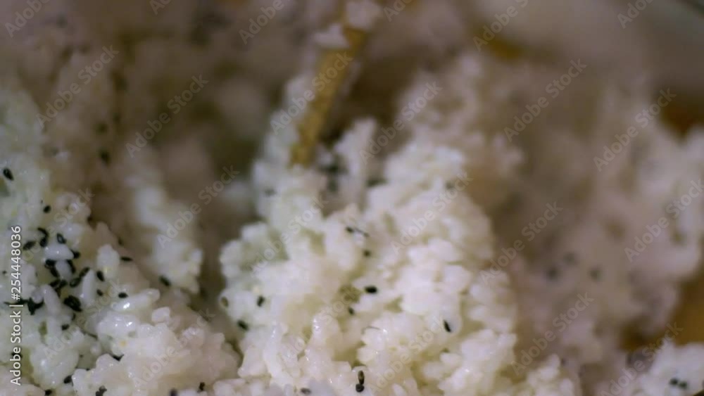 Slow Motion of cooked white rice for making sushi and rolls. Close-up of man chef hands preparing traditional Japanese food at home or in restaurant on kitchen table.-Dan Slow Motion of cooked white rice for making sushi and rolls. Close-up of man chef hands preparing traditional Japanese food at home or in restaurant on kitchen table.-Dan