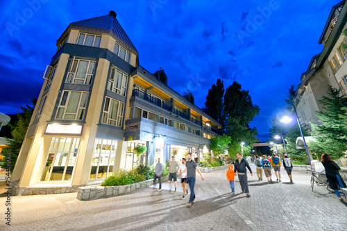 WHISTLER, CANADA - AUGUST 12, 2017: Tourists visit city center on a summer night. Whistler is a famous mountain destination in British Columbia