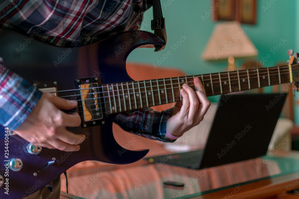 Obraz premium Man learn playing electric guitar at home