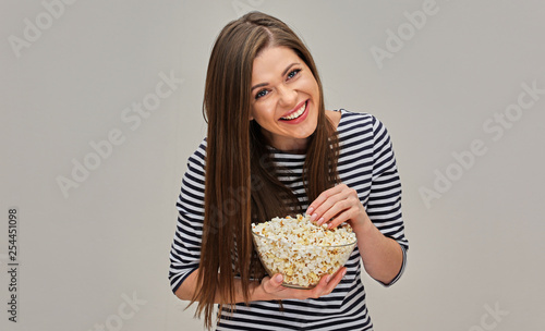 Laughing woman eating popcorn. Model dressed in striped