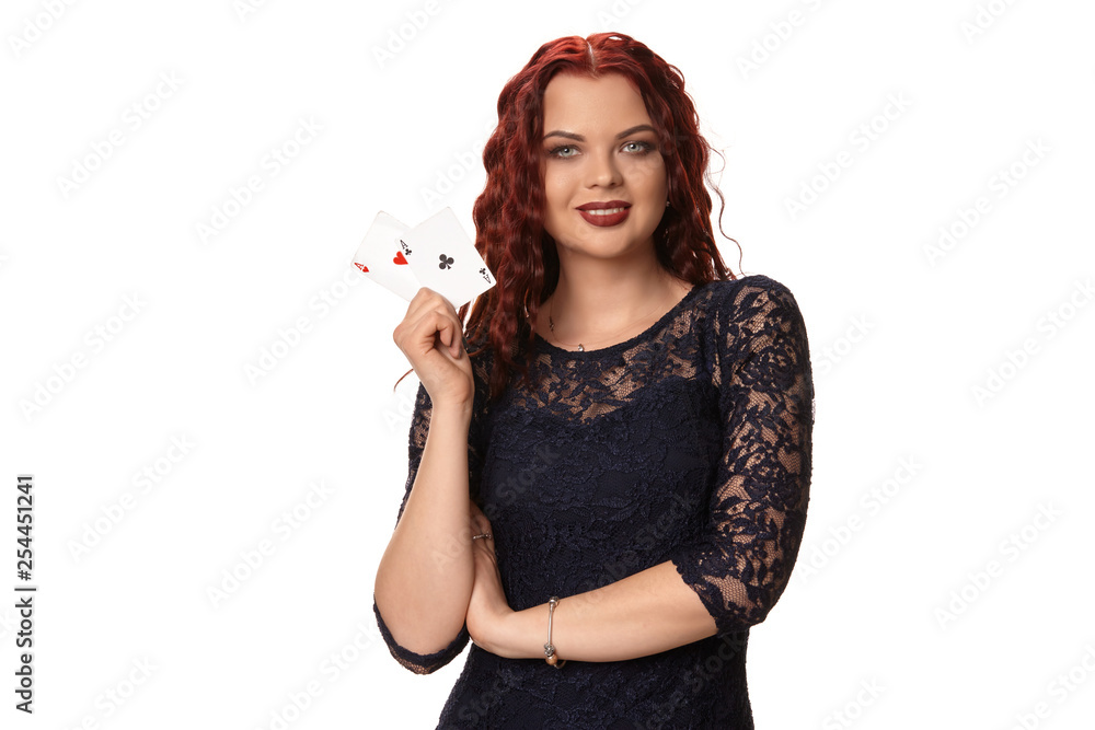 Young woman with a long red hair in evening outfit, holding playing cards. Isolated on white. Poker