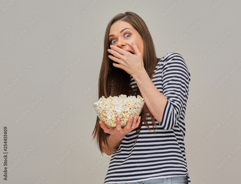 Woman with fear emotion holding popcorn and watching horror cinema Woman with fear emotion holding popcorn and watching horror cinema