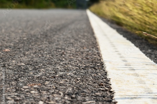 Wallpaper Mural grass beside old and dirty white line on asphalt road Torontodigital.ca